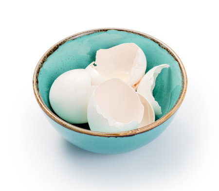 Blue bowl with eggshell isolated. Eggshell in bowl on white background.の写真素材