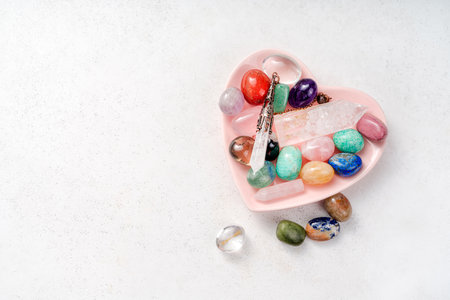 Gemstones for esoteric spiritual practice. Reiki therapy concept. Feng Shui, Healing Crystal Ritual, Witchcraft, Relax Chakra, litho therapy. Crystals on pink plate.の写真素材