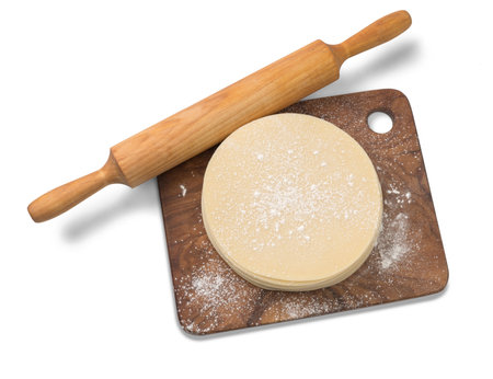 Stack of slices of dough with rolling pin on wooden board. Top view of dough.の写真素材