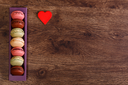I love Macaroon cakes concept. Different types of macaron with heart. Colorful almond sweet cookies. Wooden rustic board.の写真素材