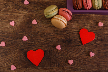 Macaroon cakes with love hearts. Valentines day concept. Colorful almond sweet cookies. Wooden rustic board.の写真素材