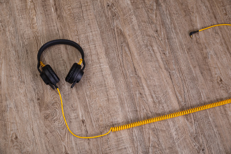 Headphones with yellow cable. Modern device for listening music. Sound earphones with socket jack...