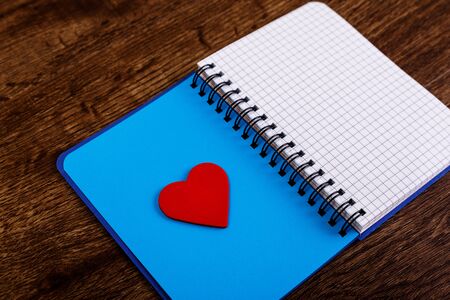 Red heart on the open blank notebook. Valentines day concept with empty notepad. Womens diary. Love...