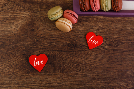 Macaroon cakes with love hearts. Love text. Valentines day concept. Colorful almond sweet cookies. Wooden rustic board.の写真素材
