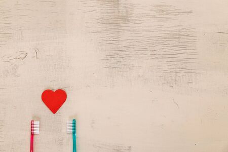 Love concept with hearts and toothbrushes. Valentines day design on wood vintage background. Wooden rustic board.の写真素材