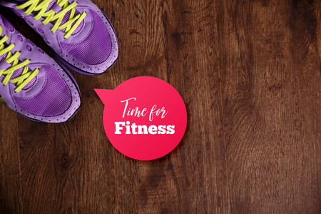 Fitness gym equipment. Purple sneakers. Workout footwear. Time for fitness speech bubble. Grunge rustic wood background.の写真素材