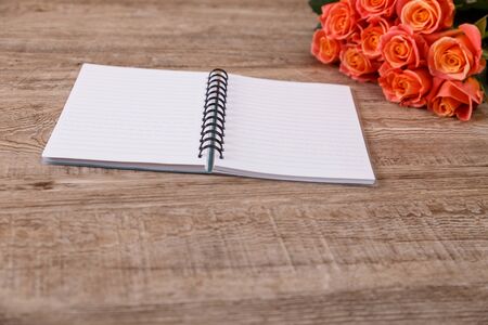 Pink roses with notebook. Valentines day concept. Love design. Wooden rustic board.の写真素材