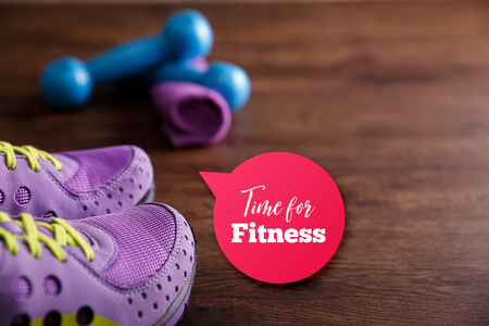 Fitness gym equipment. Sneakers, dumbbells with towel. Time for fitness speech bubble. Workout footwear. Grunge rustic wood background.の写真素材