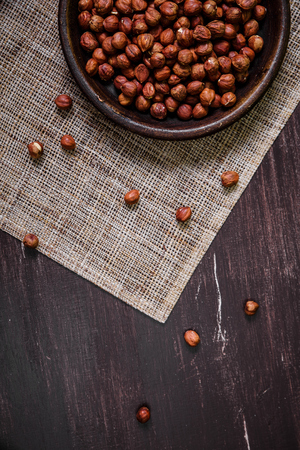 Hazelnut in bowl. Peeled nuts. Organic food on rustic wooden table with sackcloth. Top view.の写真素材