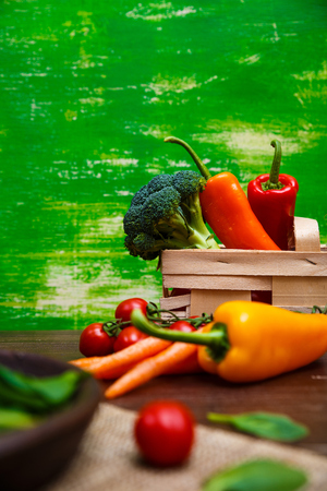 Sweet pepper, brocoli and cherry tomatoes. Brocoli and red radish. Natural raw vegetables. Organic bio food on rustic wooden table.の写真素材