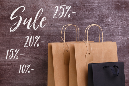 Mockup of blank shopping bags. Sale discounts. Brown and black craft packages. Concept for sales or...