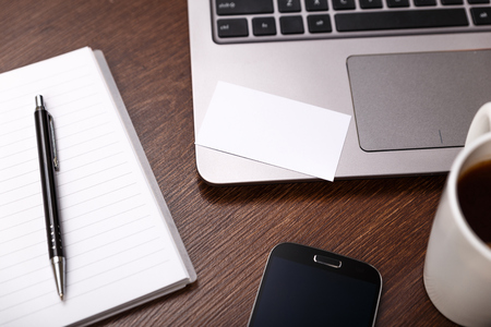 Blank business card design mockup. Visiting card, smartphone and laptop. Business branding template. Cup of coffee.の写真素材