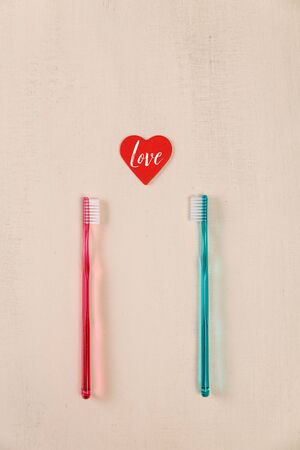 Love concept with hearts and toothbrushes. Love text. Valentines day design on wood vintage background. Wooden rustic board.の写真素材
