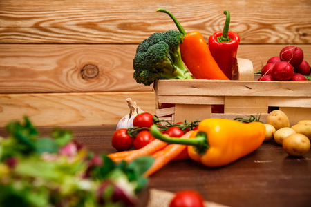 Sweet pepper, brocoli and cherry tomato. Mix salad leaves. Natural raw vegetables. Organic bio food on rustic wooden table.の写真素材