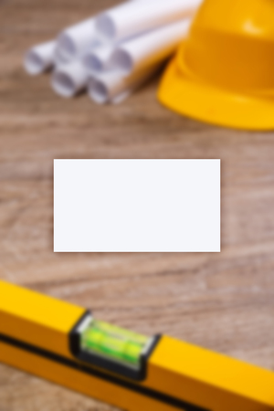 Business card mockup. Helmet, paper plans and building level. Construction design. Wood rustic background.の写真素材