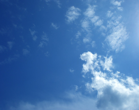 On brightly blue sky white air clouds float.Highly in the sky the bird flies.の写真素材
