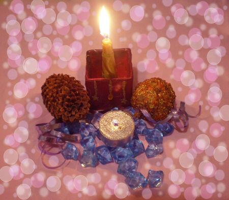 The pink background has various white circles.The pink background has effect bokeh. On a pink background there are blue crystals, the cone, ornaments and burning candles.の写真素材