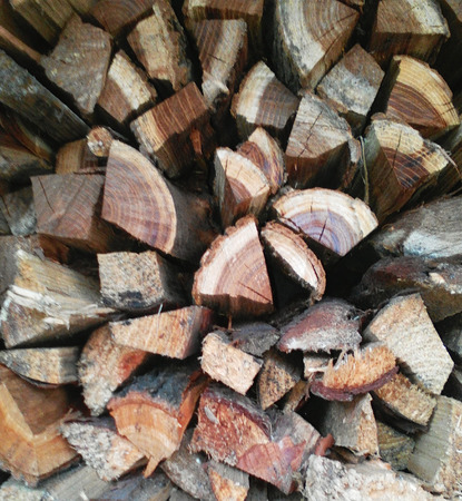 Background the tree for a fireplace is combined by a wall. Wooden logs brown and old pieces of a treeの写真素材