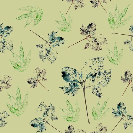 On a pale yellow background is a seamless pattern of multi-colored leavesの写真素材