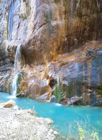 Background of a mountain landscape with waterfalls near a mountain blue river.の写真素材
