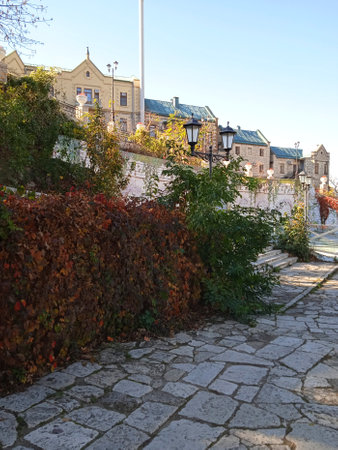 Old town street with stone pavement on a sunny day. Ancient houses illuminated by sunlight.の写真素材