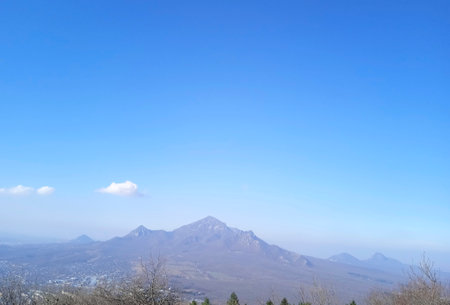 The mountains in the distance are covered with a light haze. Mountains against a bright blue skyの写真素材