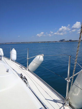 View from the deck of a sailboat to the blue sea and the cityの写真素材