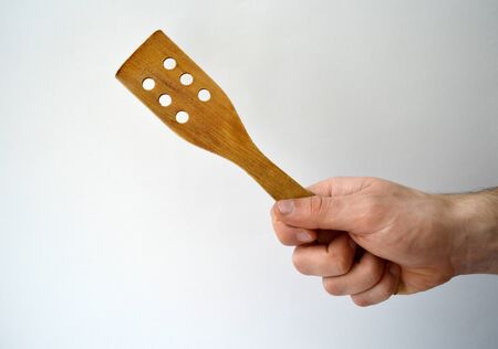 Man's hand with wooden spatula isolated on whiteの写真素材