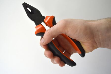 Man's hand holding pliers isolated on white backgroundの写真素材