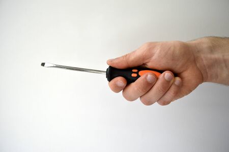 Male's hand holding screwdriver isolated on white backgroundの写真素材