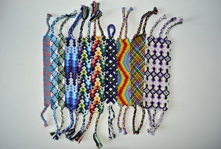 Multicolored friendship bracelets with different patterns handmade of thread isolated on white backgroundの写真素材