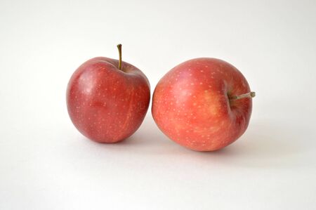 Two large appetizing red apples isolated on white backgroundの写真素材