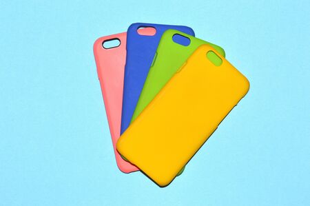 Colorful phone cases isolated on blue backgroundの写真素材