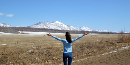 Slender brunette woman embracing  nature with open arms. The foot of the snowy mountains. concept of...