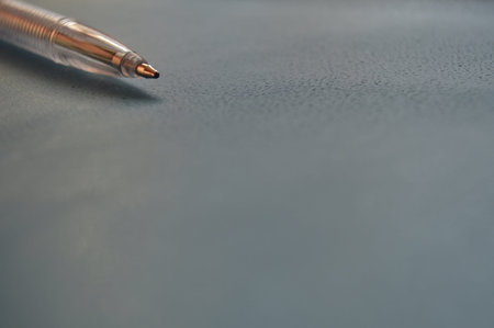 Ballpoint pen in the corner of the gray background with copy spaceの写真素材