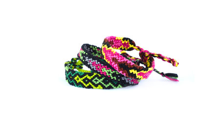 Woven friendship bracelet with bright colorful pattern handmade of thread isolated on white...