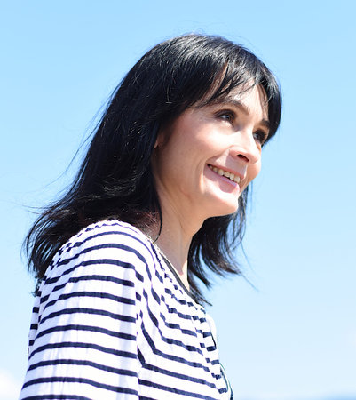 45 years old Russian woman laughing and standing against blue sky