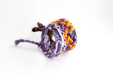 Woven DIY friendship bracelets handmade of embroidery bright thread with knots on white backgroundの写真素材