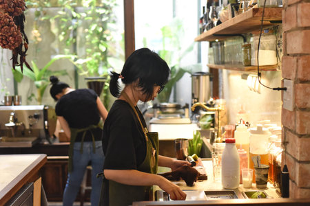 Vietnamese waitress getting ready an order in a coffee shop