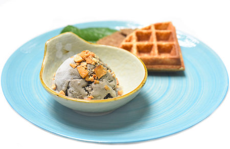Organic coconut ice cream with waffles on a blue plateの写真素材