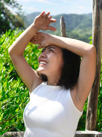 Young Vietnamese woman covering eyes from the sun at outdoor walkingの写真素材