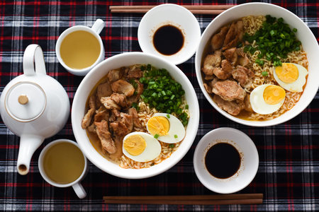 Japanese ramen with chicken and soy sauce on the table with teapot and green tea