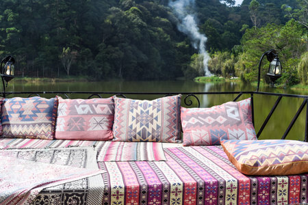 Pillows and sofa in arabian and turkish style against lake and forest