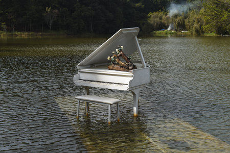 White old rusty piano inside the lake against the pine forest in Da Latの写真素材