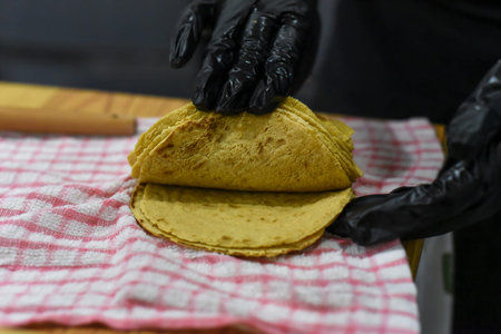 Hands cooking tortillas for tacos in a mexican restaurant