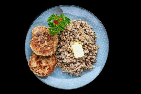 buckwheat with meat cutlets on a black background top viewの写真素材