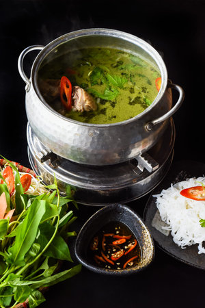 Korean hot pot with chicken meat and noodles on black background