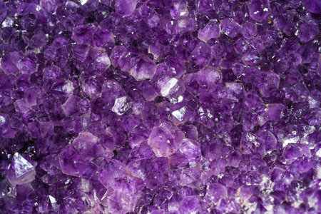 Horisontal background made of amethyst mineral close up