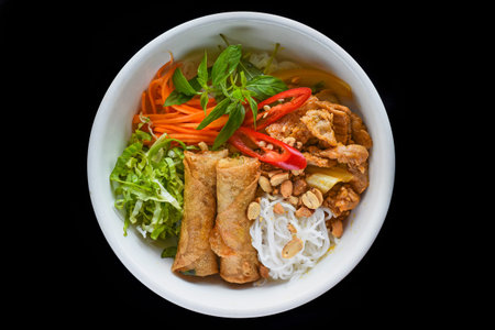 Traditional fried vietnamese spring rolls with pork served with rice noodles, fried beef and peanuts