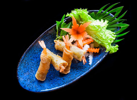 Traditional fried vietnamese spring rolls with shrimps and pork, rice paper on black backgroundの写真素材